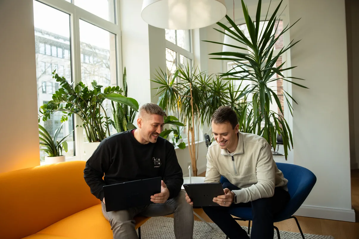 Dennis Hoffmann und Sascha Wegner arbeiten gemeinsam an Laptop und Tablet